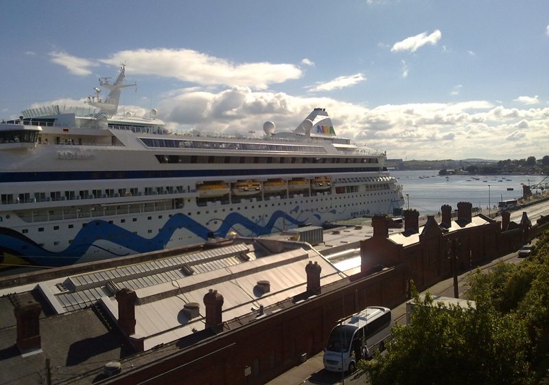 AIDAaura neben dem Bahnhof von Cobh