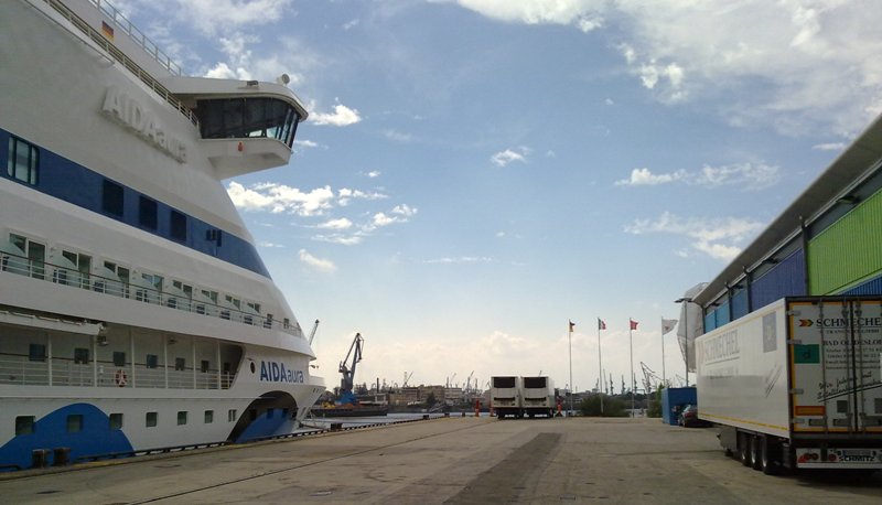 AIDAaura (links) am Kreuzfahrt-Terminal (Container-Stapel rechts) in Hamburg